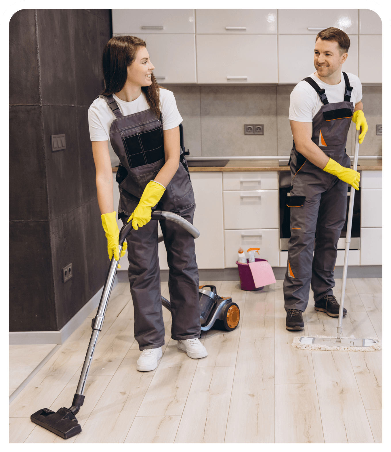 Two people cleaning a modern kitchen floor.